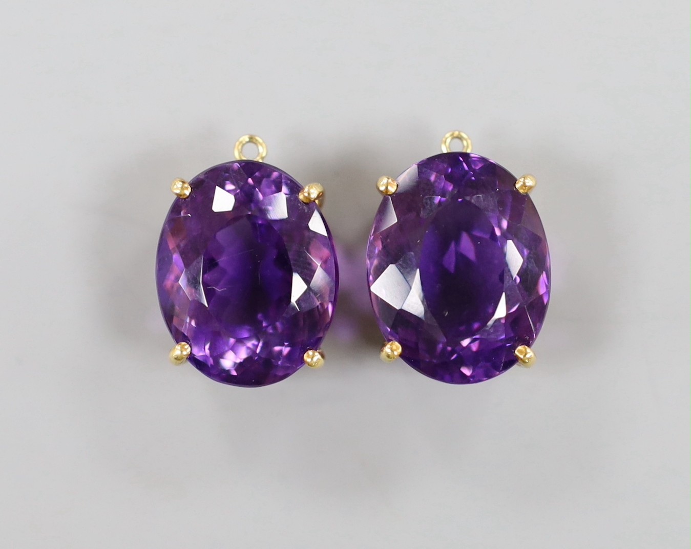 A modern pair of yellow metal mounted oval cut amethyst pendants?, 21mm, gross weight 13.8 grams.